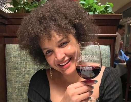 Daniella Atim sipping a on a glas of wine