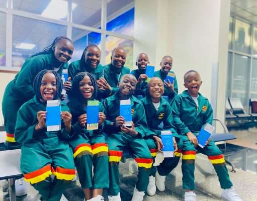 Masaka Kids Africana showing off their passports